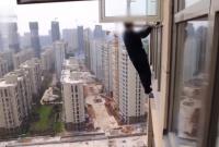 В Китае горе-грабитель пытался сбежать от полиции через окно на 22 этаже (видео)